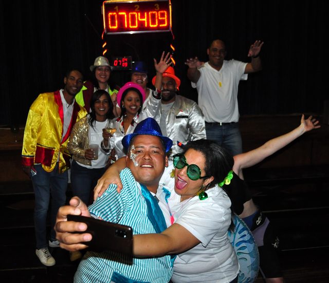Friends taking a selfie under the Musiekpret scoreboard