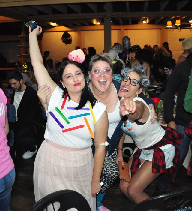 A team in costume cheering with arms raised