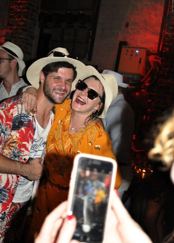 Guests in fancy dress laughing for a phone photo